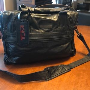 Tumi men’s black leather bag with shoulder strap.